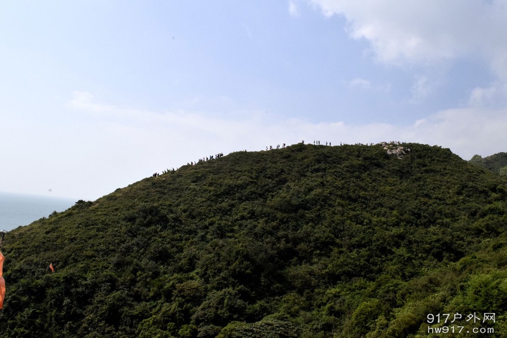 为了最美的海边行走在山脊的驴友们